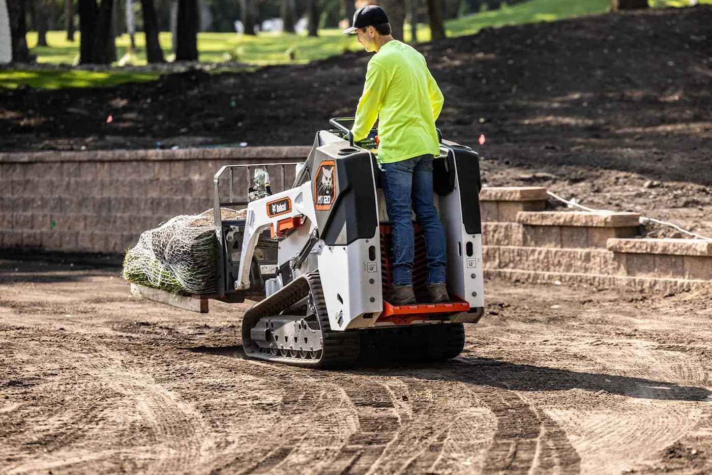 Bobcat MT-120 mini skid steer lifting a pallet with pallet forks