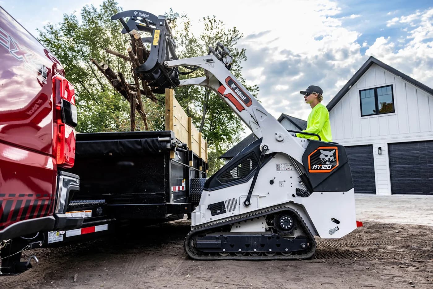Bobcat MT-120 mini skid steer running a 48 inch root grapple to clear brush, roots and logs